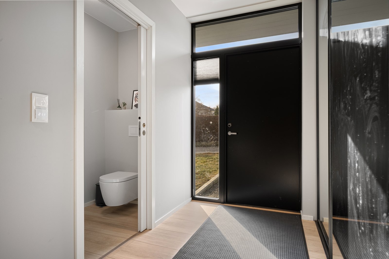 Entre/gang med skyvedørsgarderobe og tilgang til gjestetoalett. Eksklusiv høytrykkslaminat fra Berry Alloc. Galleribilde