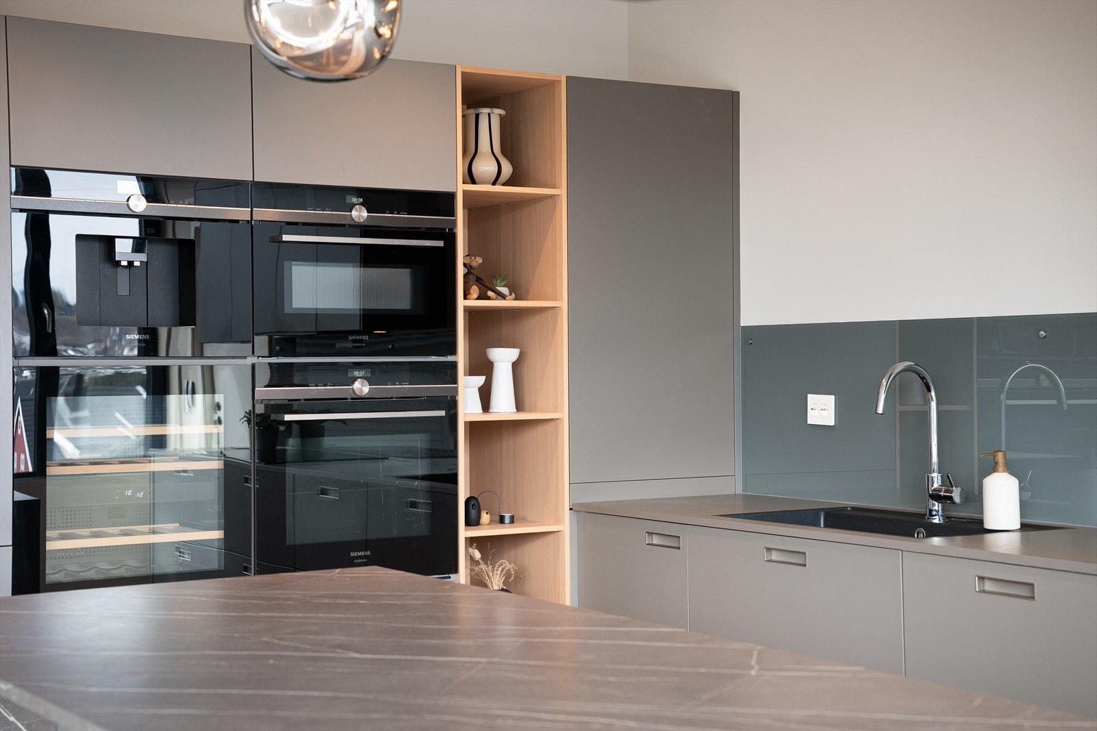 Stikkontakter i benkeplate og spesialbestilt glass langs benkeplate. Nyt utsikten mens du kokkelerer. Fin kontakt med spisestuen. Galleribilde