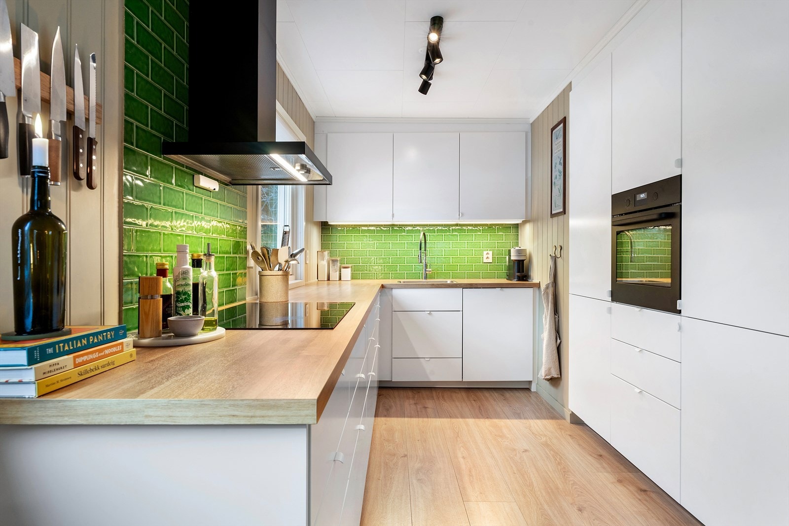 Kjøkkenet har en praktisk og arealeffektiv utforming med skap og skuffer i glatte fronter. Galleribilde