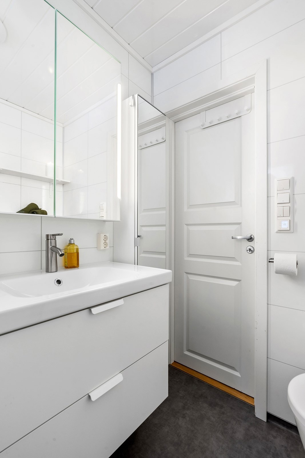 Baderomsinnredning med heldekkende servant, glatte fronter og speilskap. Galleribilde