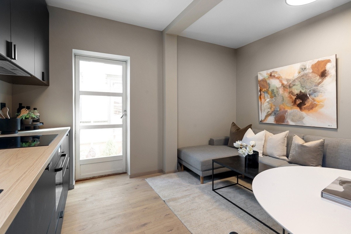 Nyoppusset kjøkken/stue med integrerte hvitevarer og møblert fellesareal Galleribilde