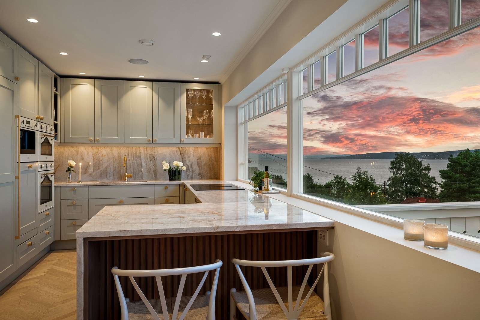 Kjøkkenbenken er laget på en slik måte at en har barløsning mot kjøkkenet og plass til to stoler Galleribilde