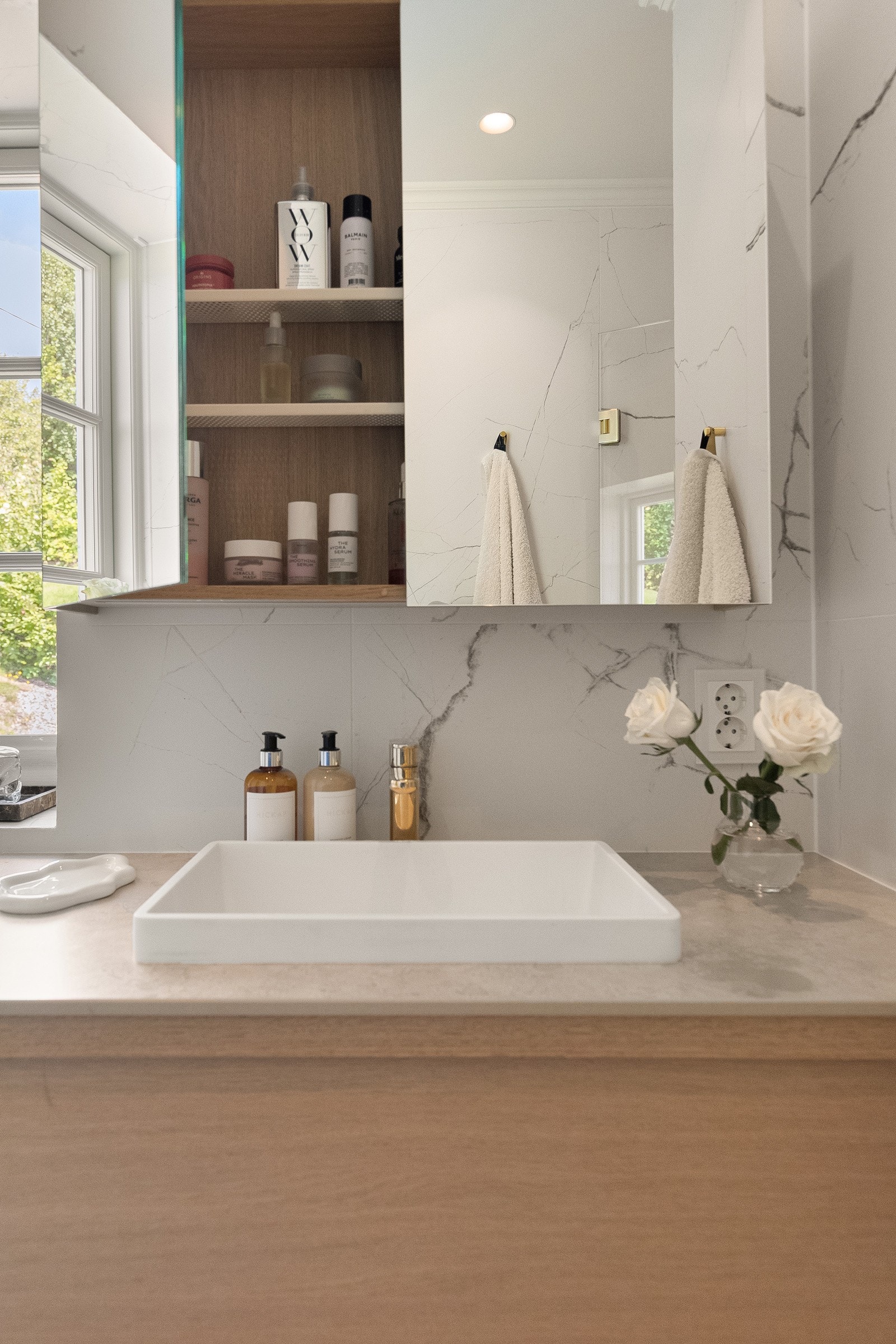 Veggskap med speilfronter og belysning over servant Galleribilde