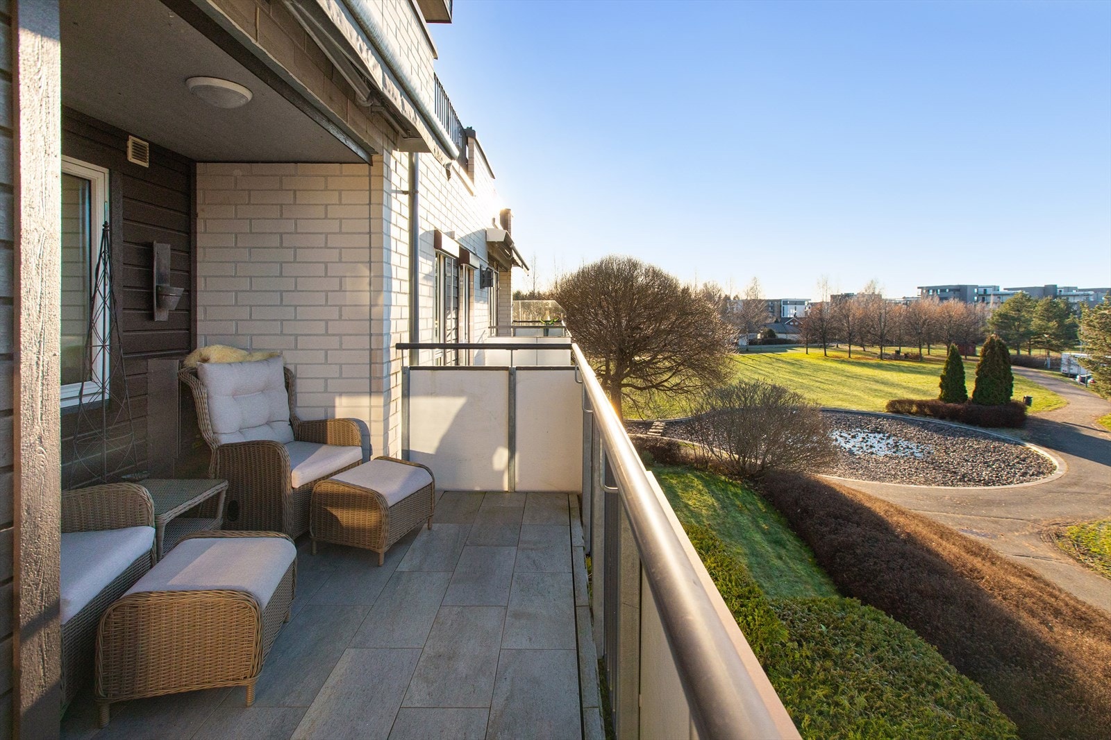 Fra balkongen har man utsyn over fellesarealet til sameiet. Her er det både markiser og utvendige persinner på flere vinduer. Galleribilde