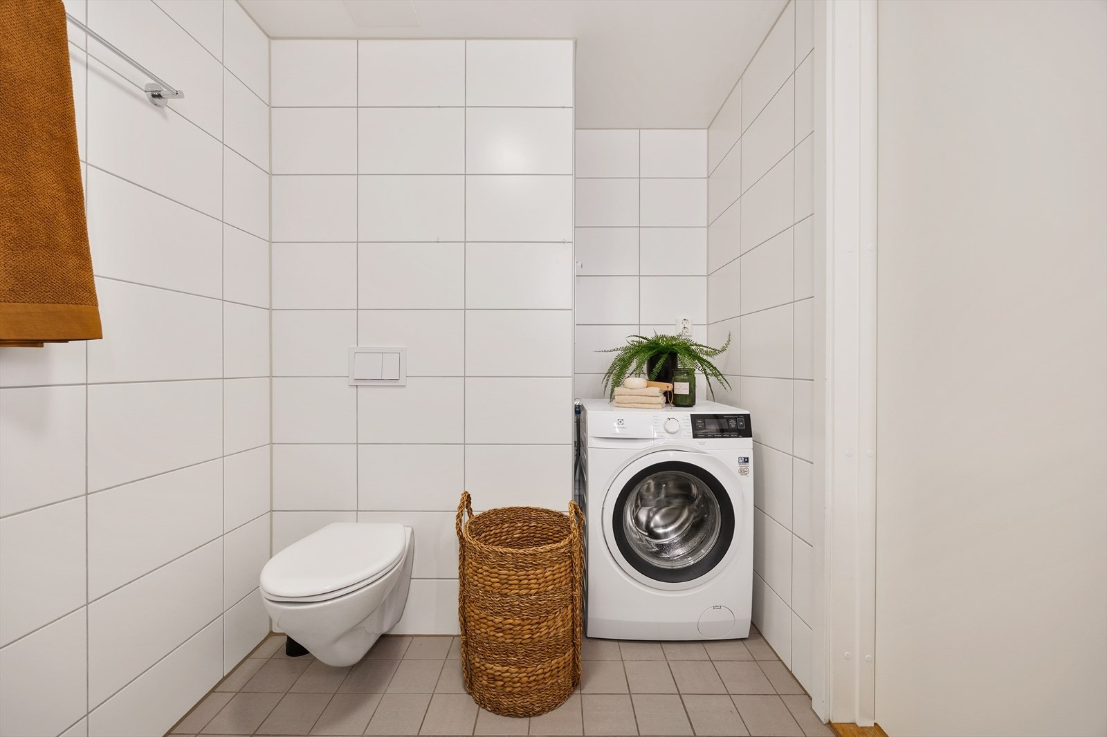 Her er det vegghengt toalett med innebygget sisterne og opplegg for vaskemaskin. Galleribilde