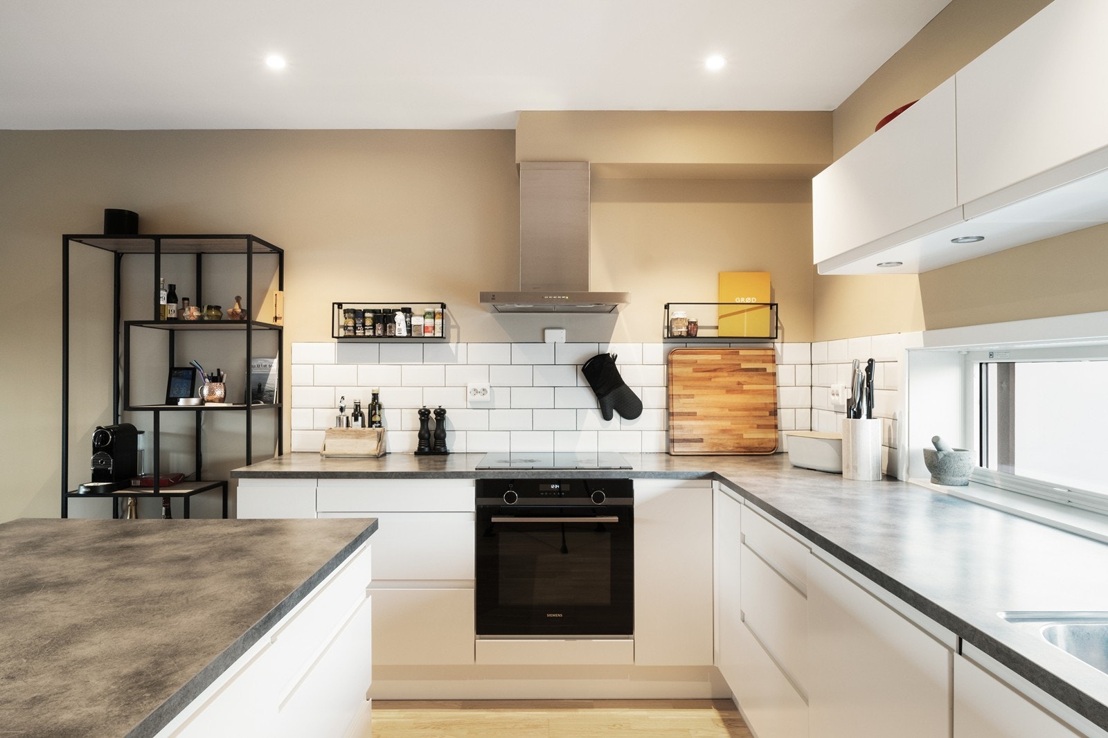 Kjøkkeninnredning med glatte, hvite fronter og integrerte hvitevarer. Galleribilde