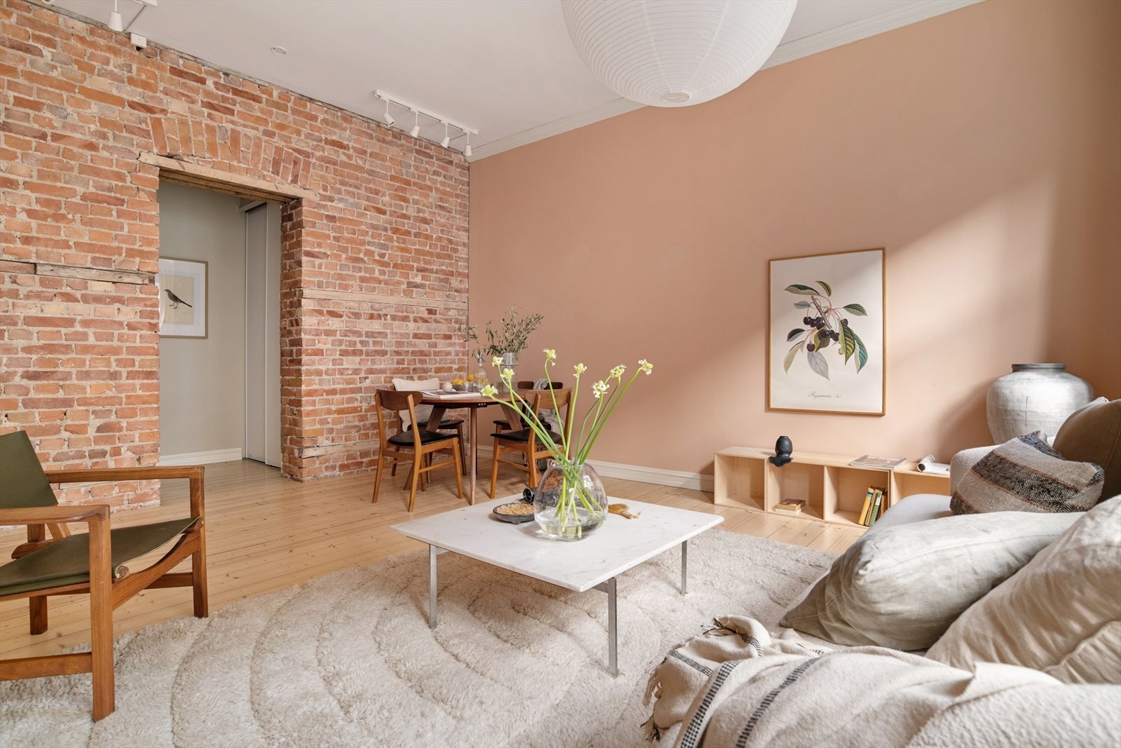 Den store teglsteinsveggen gir rommet et tøft særpreg. Det er god plass til en spisestue. Rundt eller rektangulært spisebord? Du bestemmer! Galleribilde