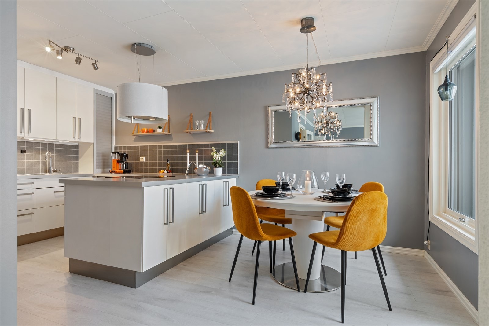 Åpen løsning til kjøkken med tidløs innredning. Hvite, slette fronter og laminert benkeplate. Galleribilde