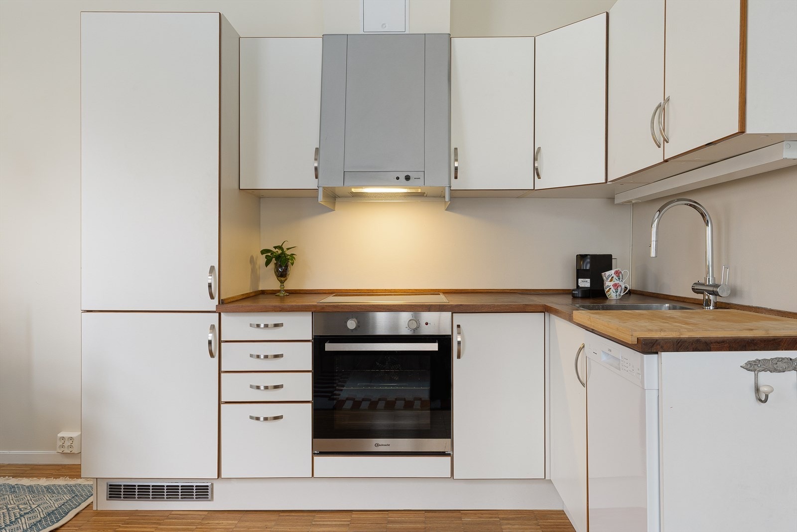 Innredningen fra HTH har glatte fronter, heltre benkeplate med oppvaskkum og 1-greps blandebatteri, lys under overskap og ventilator med mekanisk avtrekk. Galleribilde