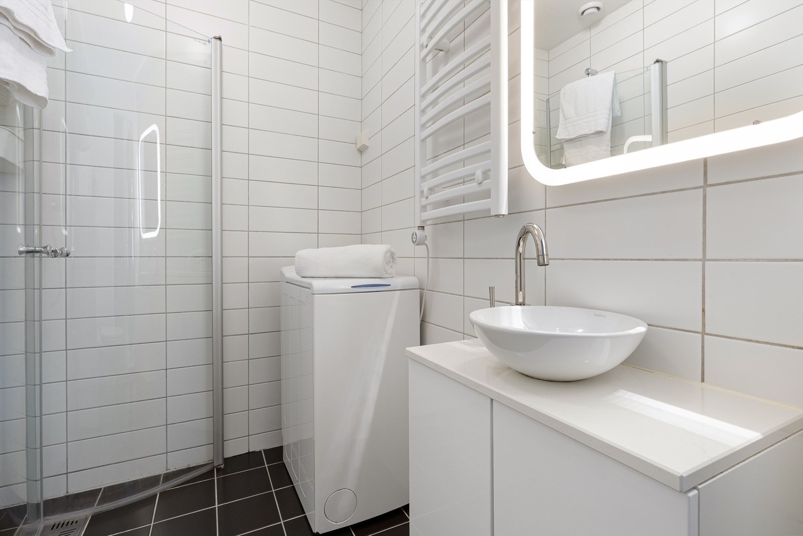 Badet er har opplegg for vaskemaskin. Praktisk håndkletørker og speil med LED-lys. Varmekabler har vært i bruk, men er i dag koblet ut pga. jordfeil. Selger har fått estimert pristilbud for å ordne dette. Ta kontakt med megler for ytterligere informasjon. Galleribilde