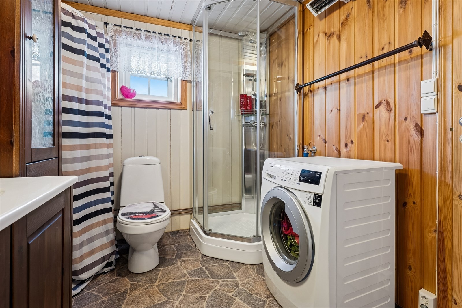 Praktisk bad og vaskerom med dusjkabinett og opplegg for vaskemaskin. Galleribilde