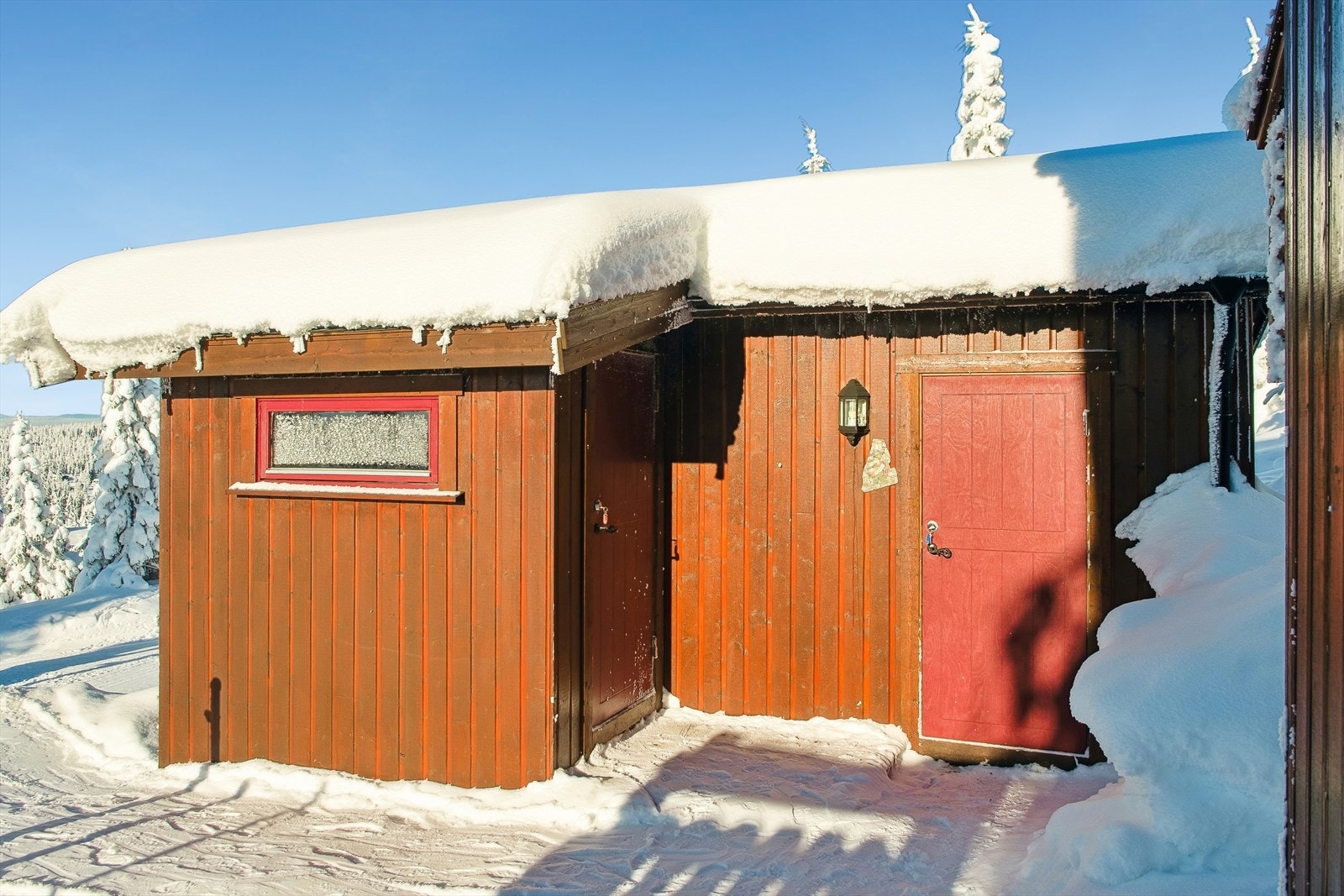 Et frittstående uthus på 16 m² gir rikelig med lagringsplass for ski, ved og utstyr. Galleribilde
