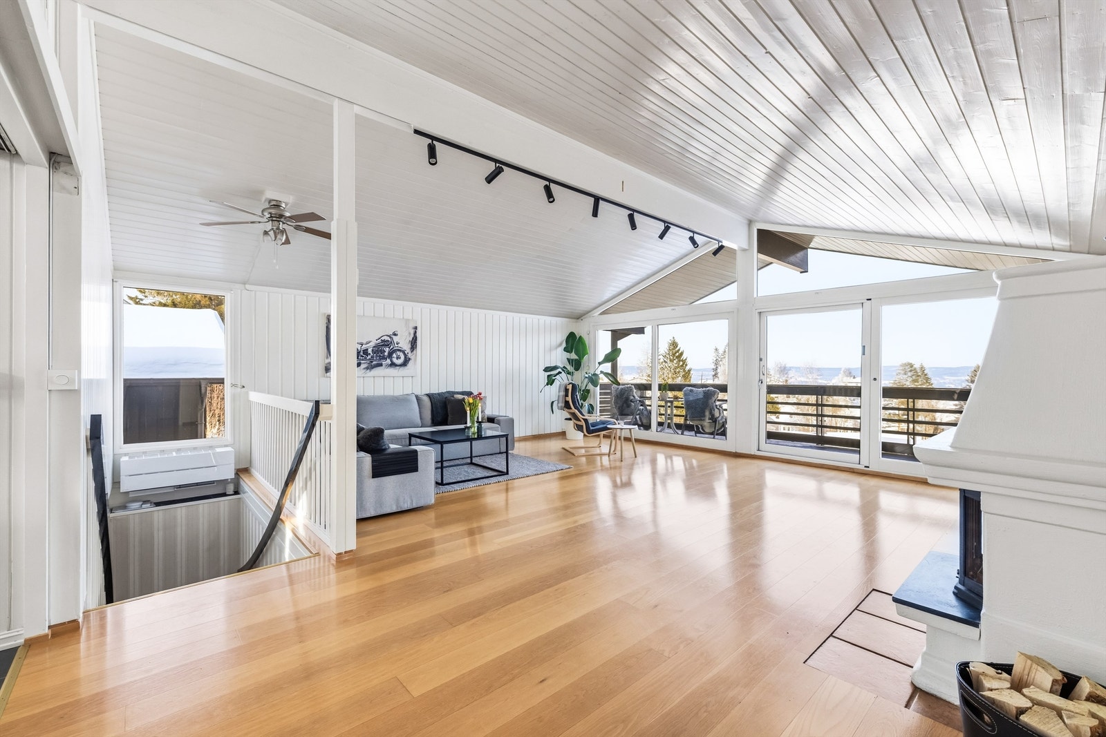 Trappen leder opp til en lys og luftig stue med store vindusflater. Galleribilde