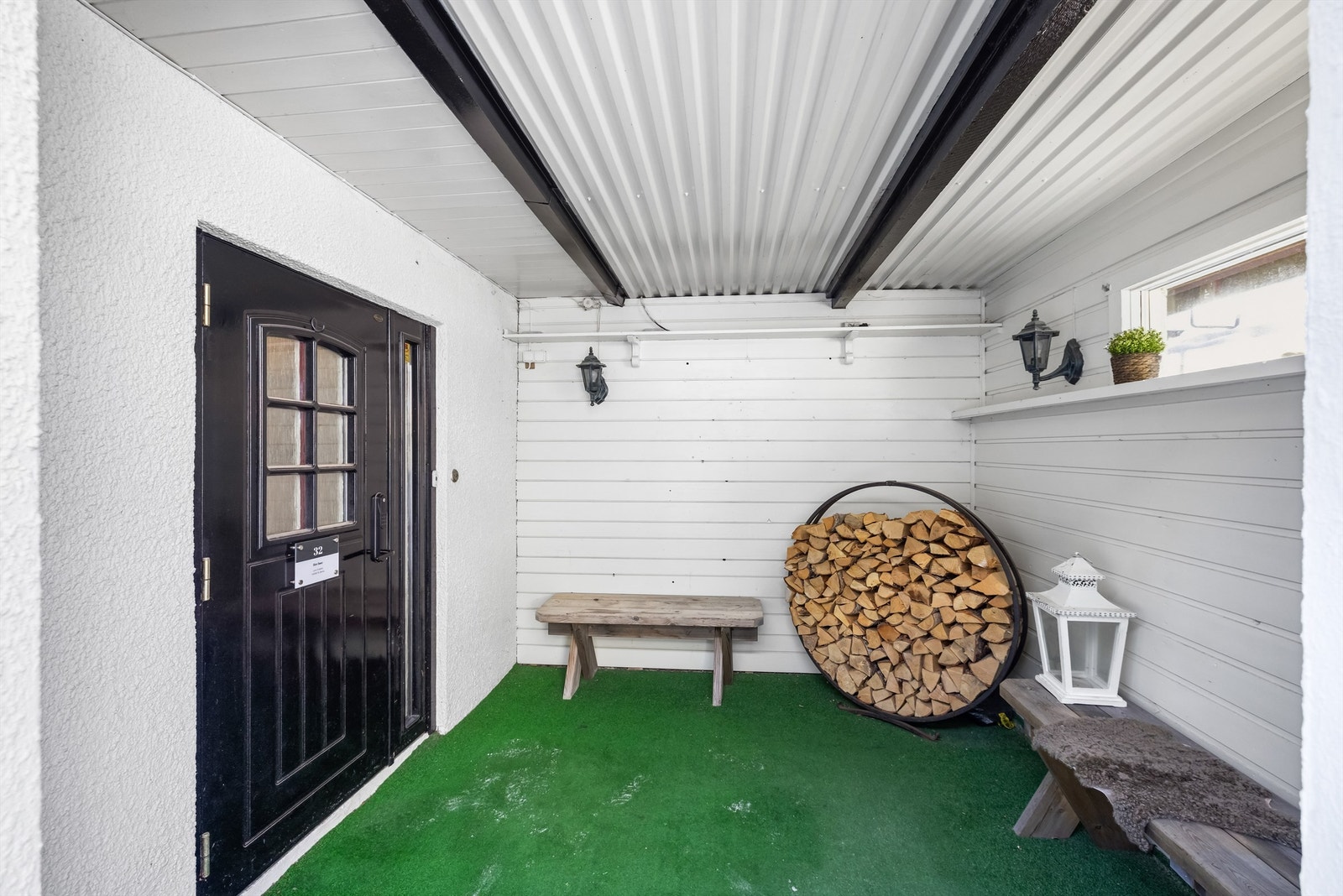 Overbygget inngangsparti til underetasjen med plass til ved. Galleribilde