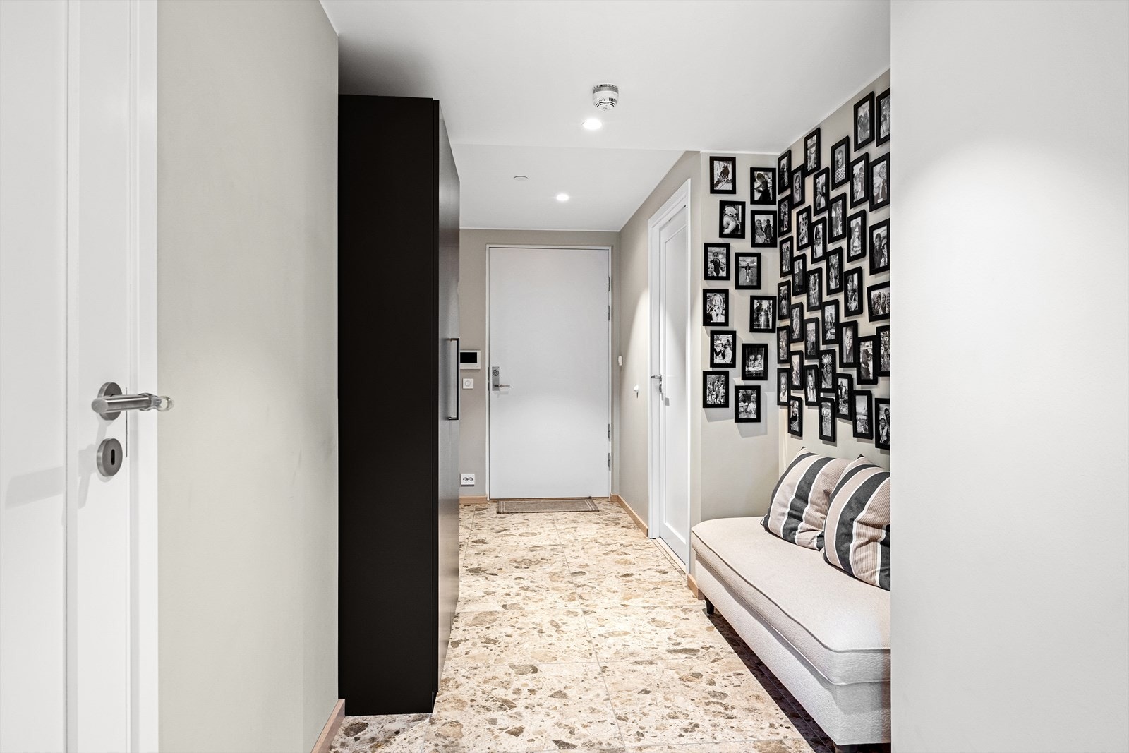 Boligens entré setter tonen med et elegant og funksjonelt design. Gangen er romslig og inviterende, med praktiske elementer som skapinnredning og plass for sittebenk. Galleribilde