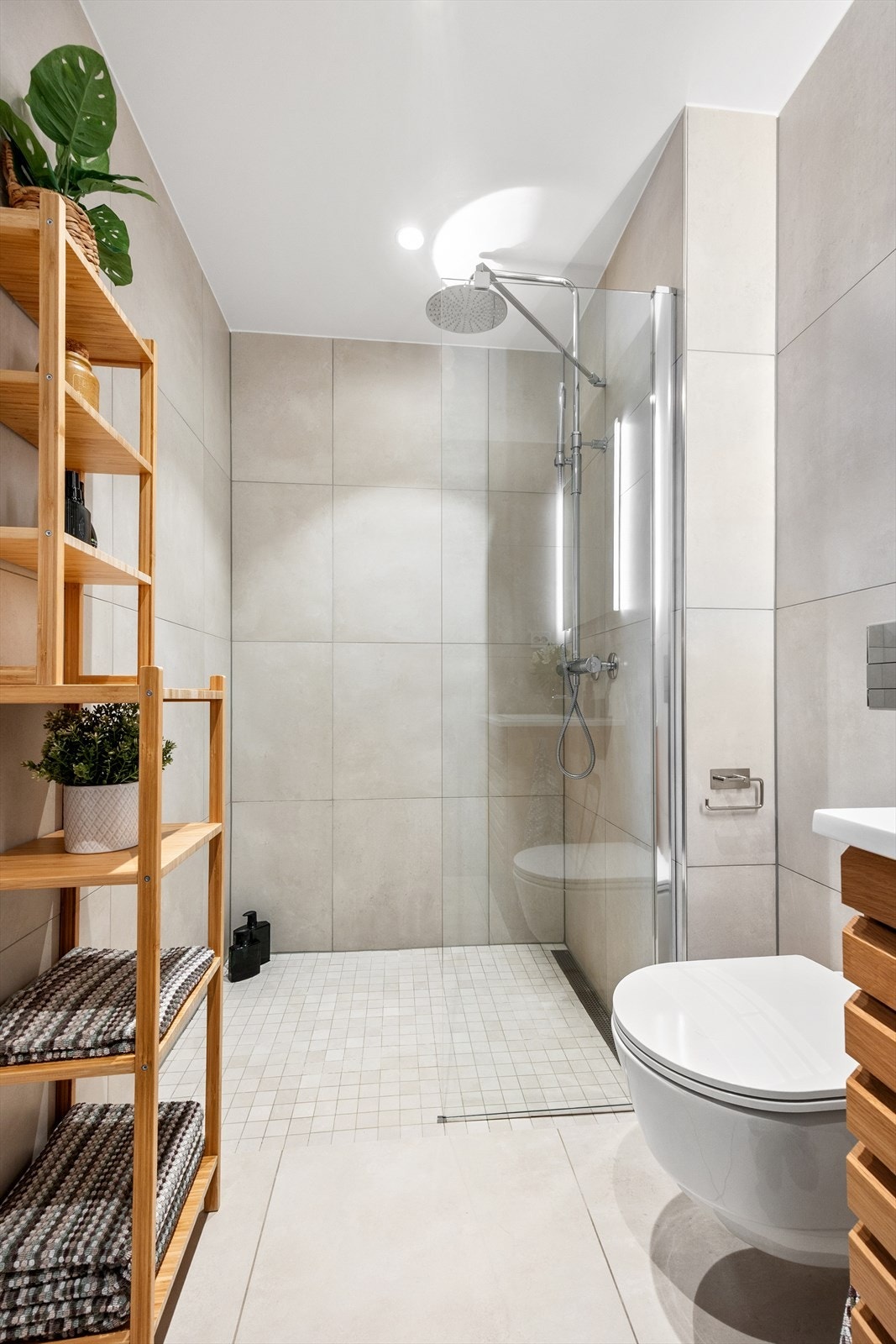 Badet har vegghengt toalett, dusjhjørne med regnfalldusj og hånddusj. Galleribilde