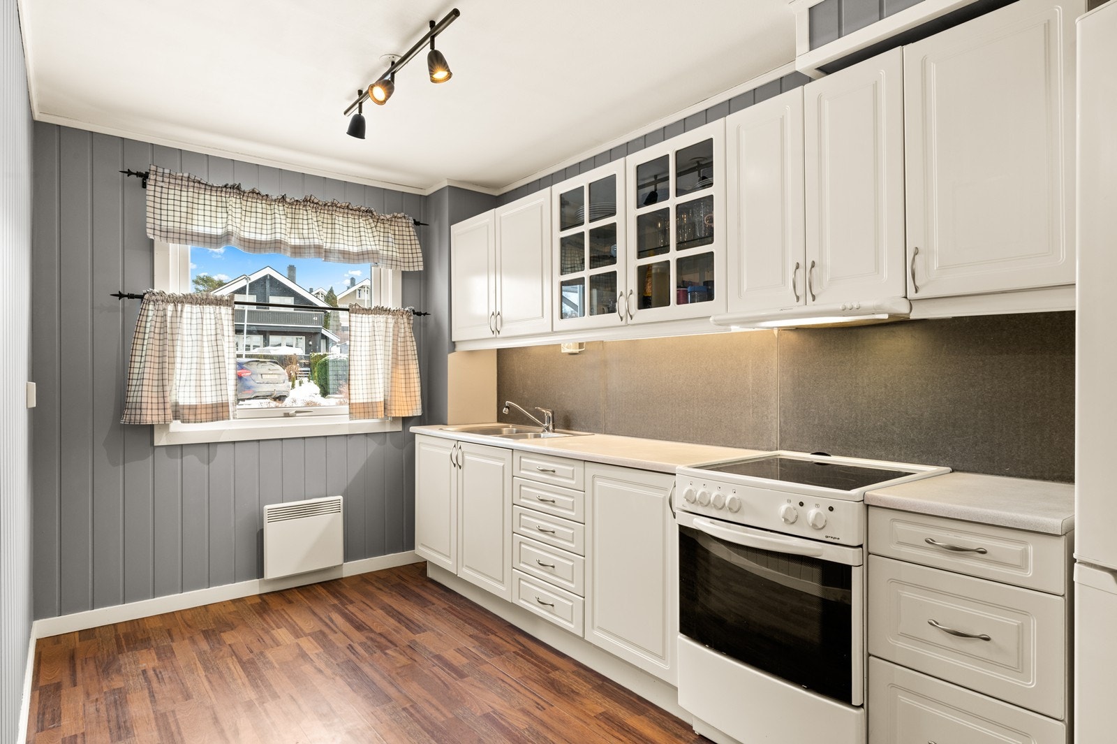 Kjøkkeninnredning med profilerte fronter, laminatbenkeplate og plass for hvitevarer. Galleribilde