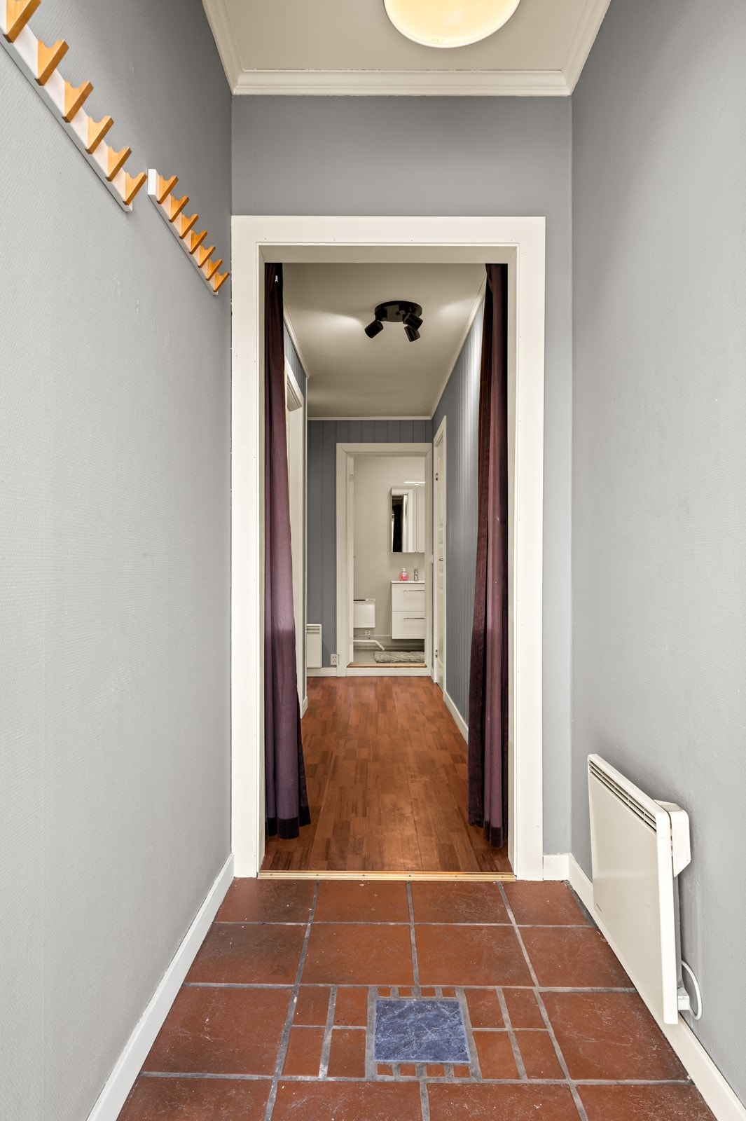 Praktisk entré med flislagt gulv som leder deg videre inn i leiligheten. Galleribilde