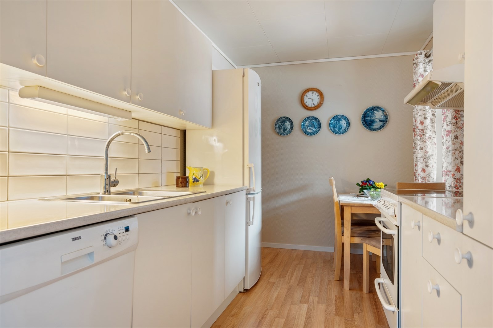 Lyst kjøkken med plass til spisebord og inngang vaskerom. Galleribilde