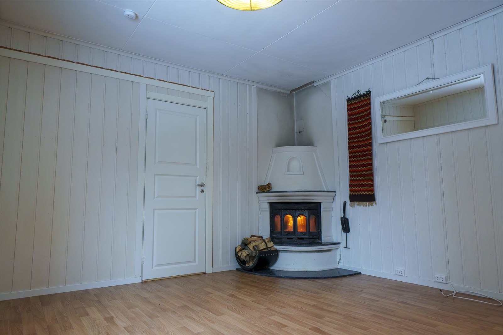 I hjørnet av stuen er det en koselig peis med innsats som både gir god varme og bidrar til ekstra hygge. Galleribilde