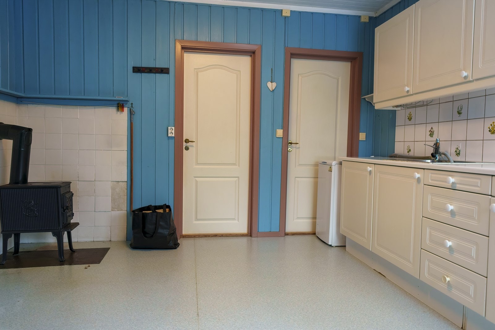 Kjøkkenet har belegg på gulv og panel på veggene malt i en fin blåfarge. Galleribilde