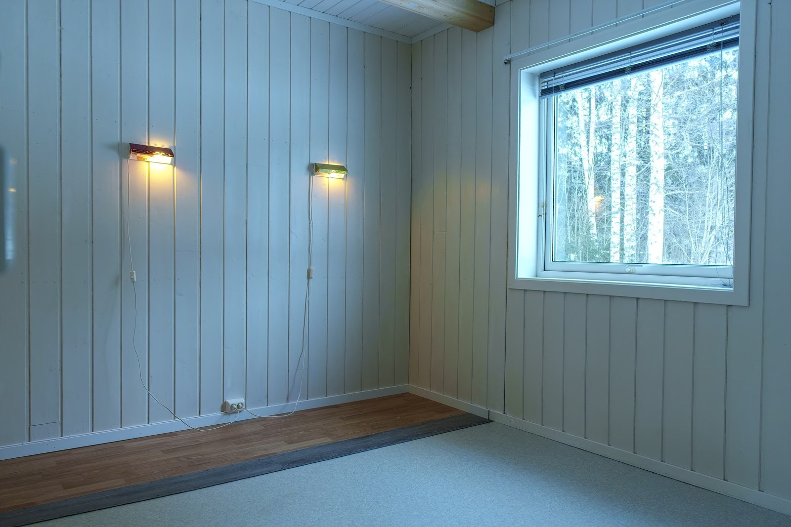 Soverom 1 ligger innenfor kjøkkenet, og har belegg på gulv og lysmalt panel på veggene. Galleribilde