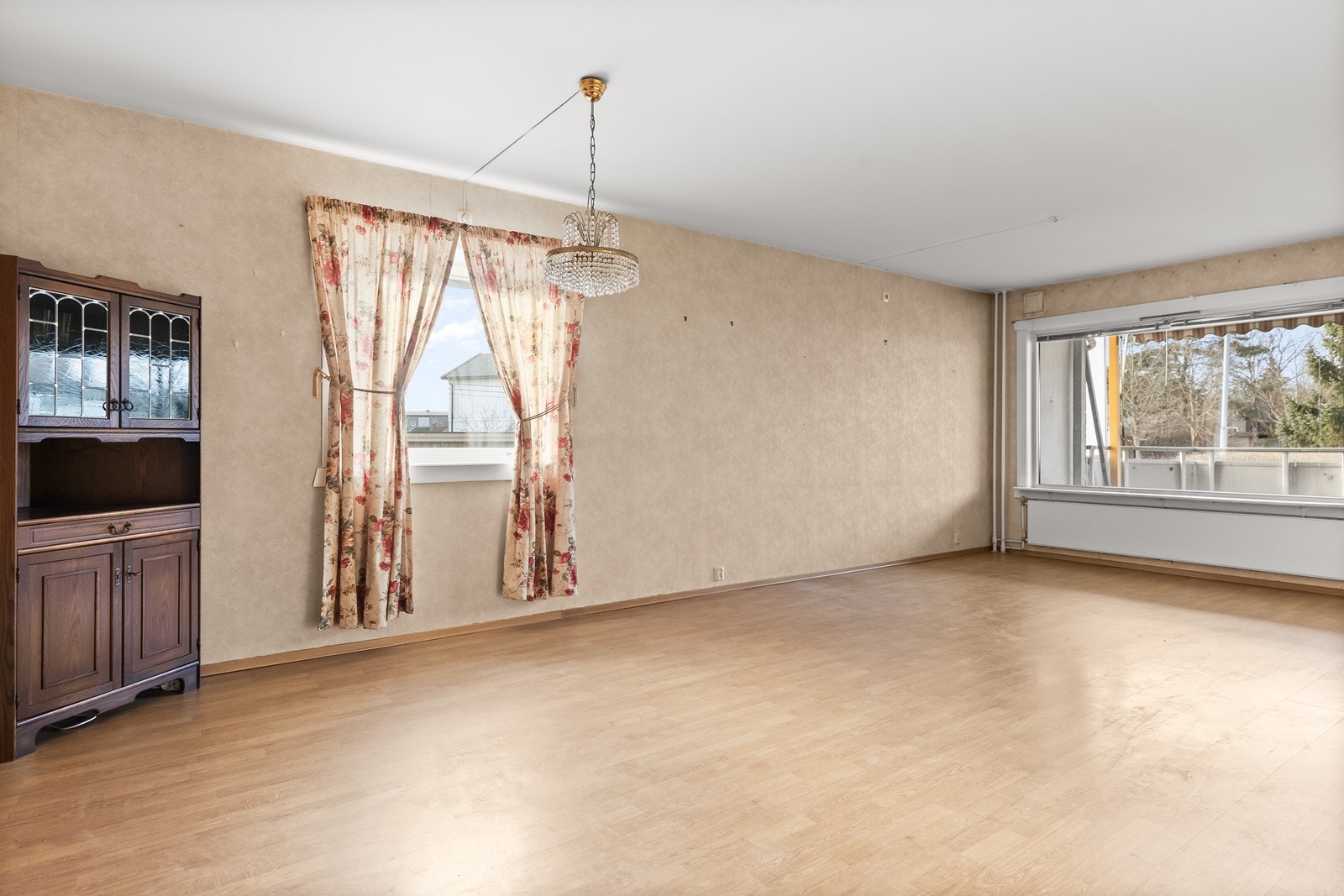 Stuen er et lyst og åpent rom med store vindusflater og oppvarming via radiatorer. Galleribilde