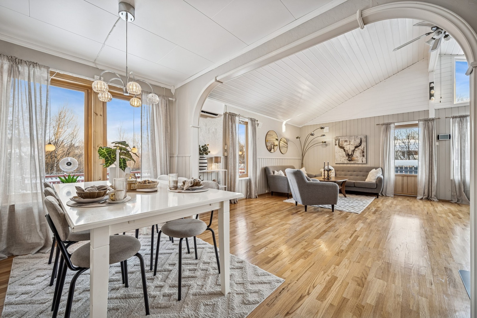 Lys og trivelig spiseplass med store vinduer som slipper inn rikelig dagslys som skaper en innbydende sone med plass til et romslig spisebord for hele familien Galleribilde