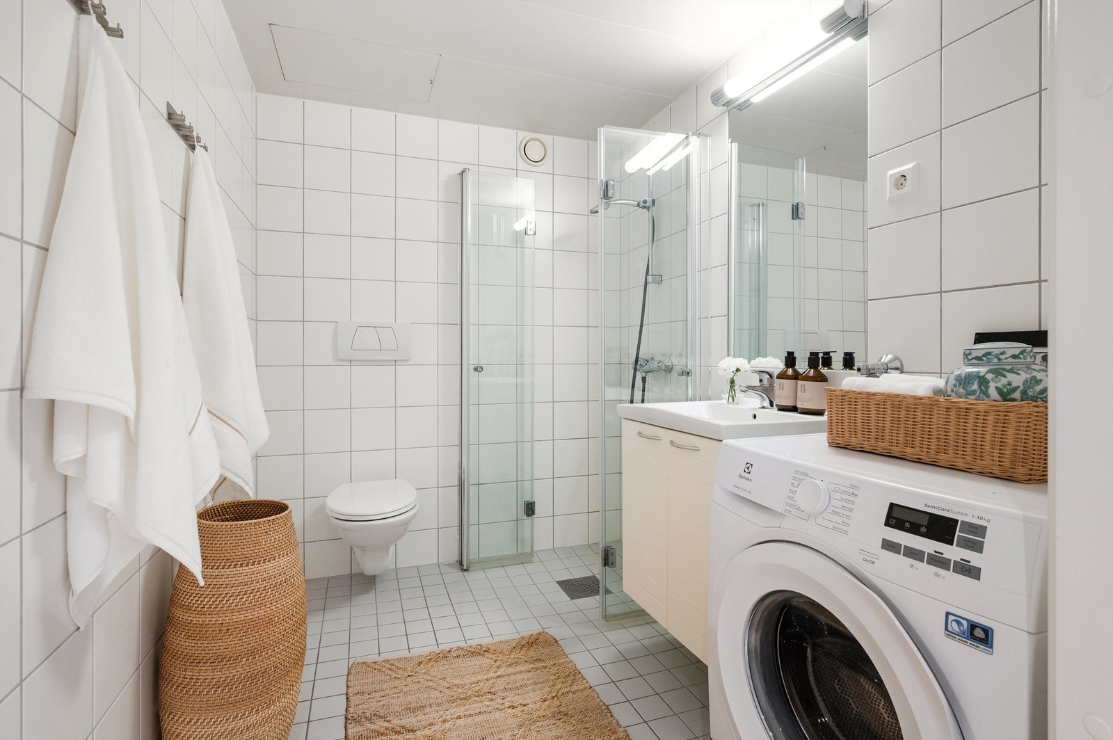 Romslig, flislagt bad med elektrisk gulvvarme og opplegg for vaskemaskin. Galleribilde