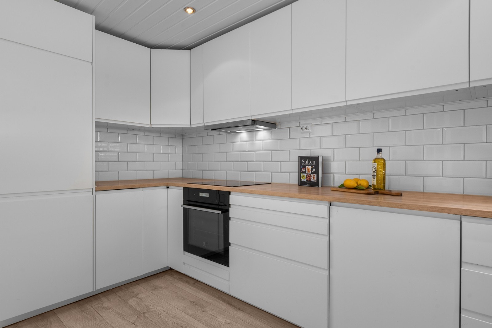 Laminat benkeplate og hvite, glatte fronter gir et stilrent uttrykk. Galleribilde