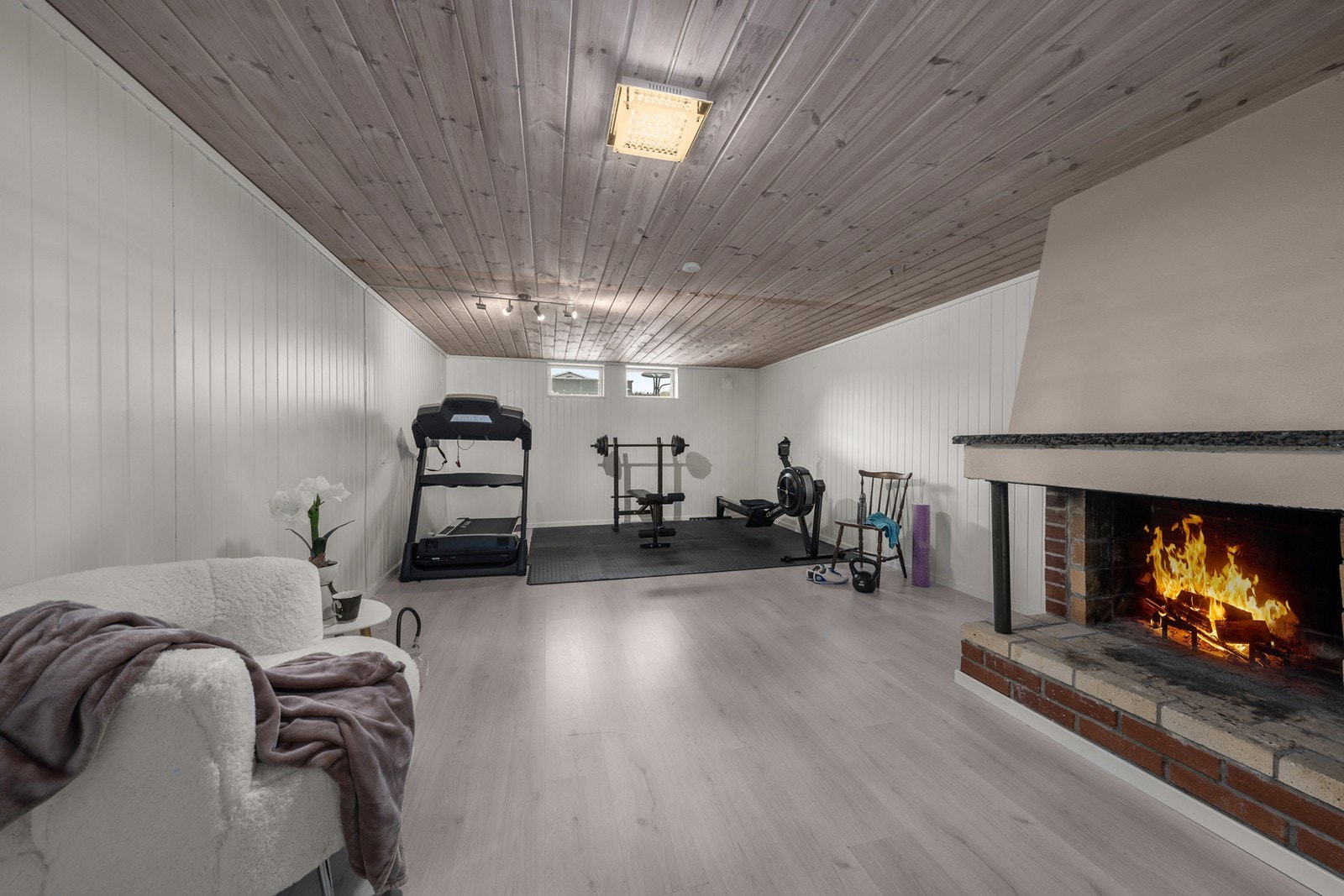 Romslig innredet kjellerstue med åpen peis for ekstra hygge. Galleribilde