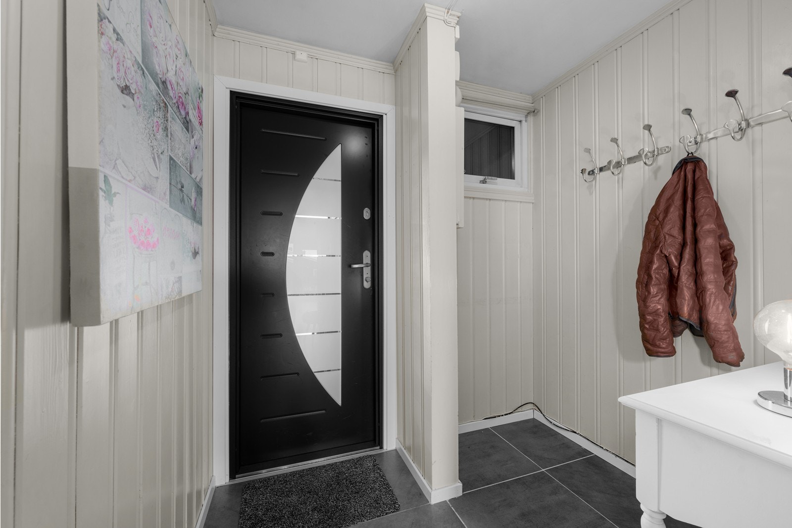 Romslig gang med flislagt gulv og plass til yttertøy. Galleribilde