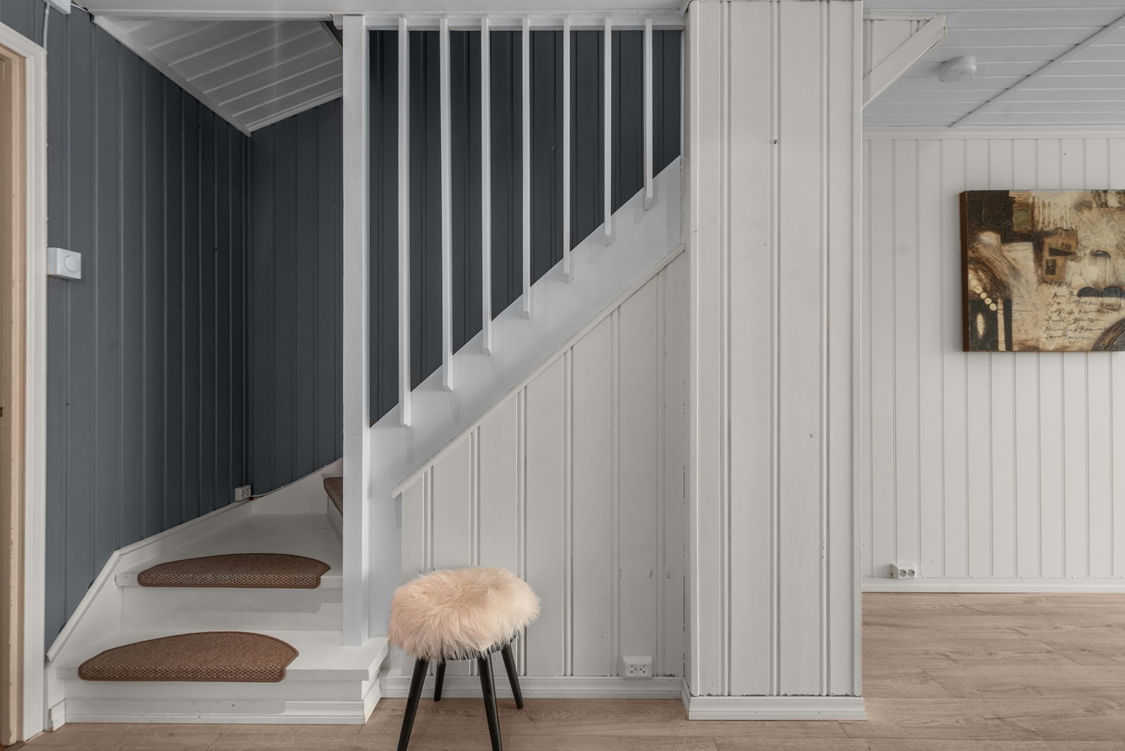 Malt tretrapp med teppebelagte inntrinn leder opp til andre etasje. Galleribilde