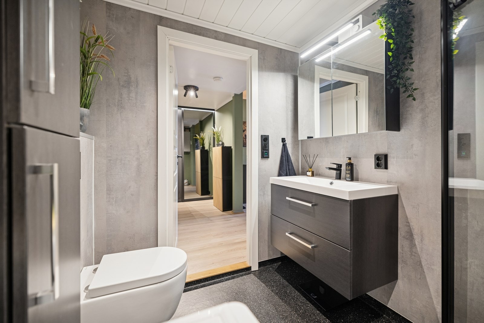 Her er det vegghengt toalett, dusjhjørne med glassdører og opplegg for vaskemaskin. Galleribilde