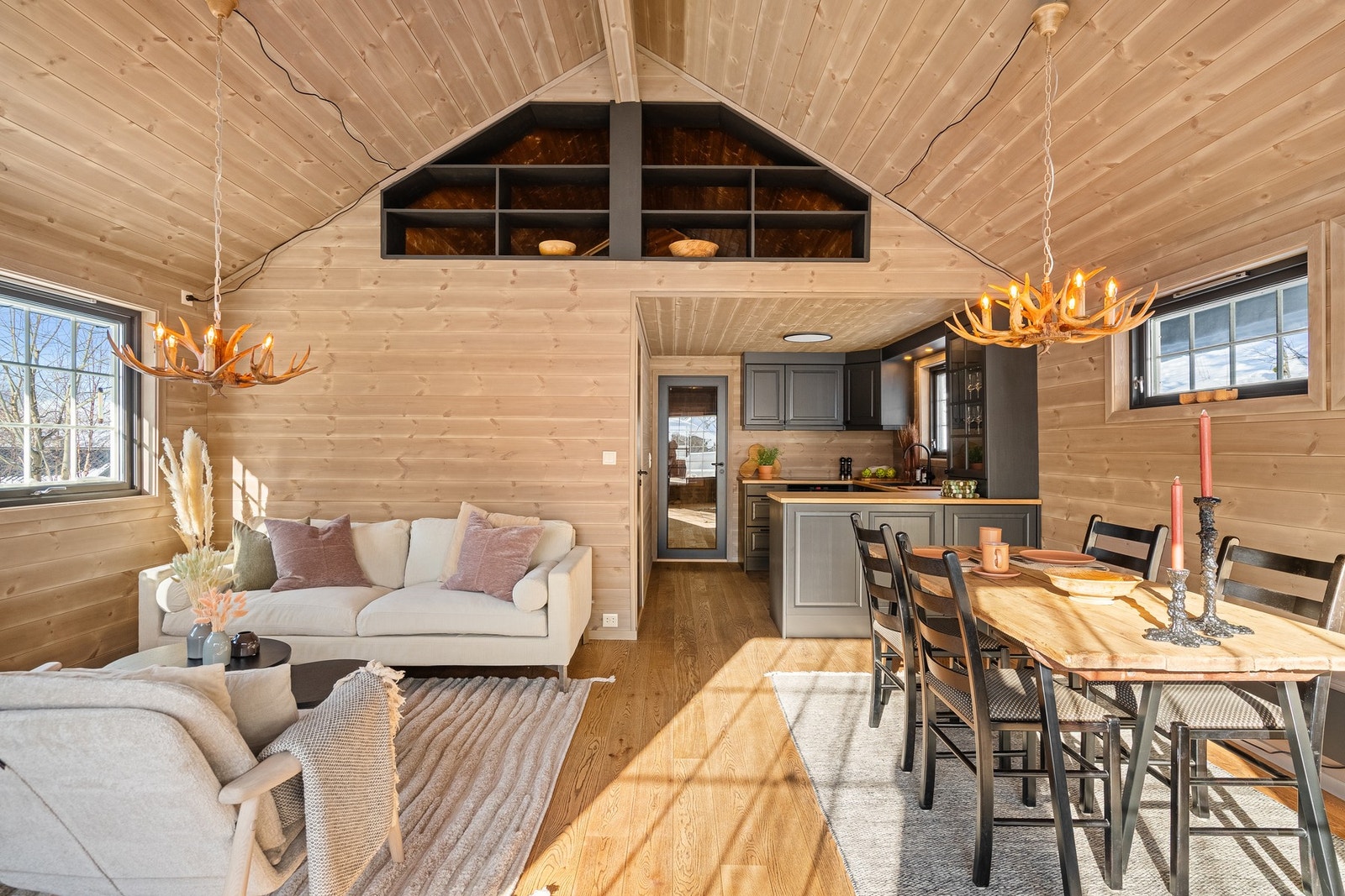 Stue og kjøkken ligger i åpen løsning til hverandre, noe som bidrar til en sosial og luftig atmosfære. Galleribilde