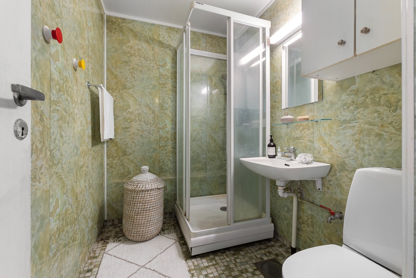 Eldre bad innredet med servant, speil, dusjkabinett, toalett, samt opplegg for vaskemaskin. Galleribilde