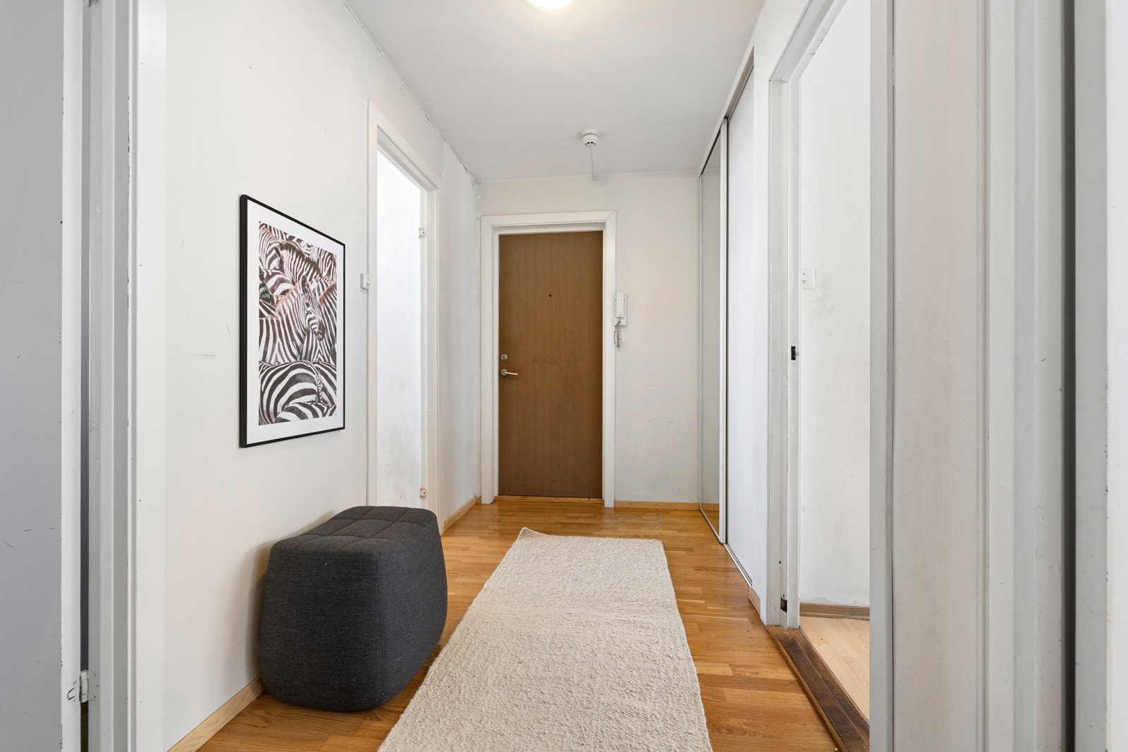 Romslig entré innredet med skyvedørsgarderobe med speilfronter. Galleribilde