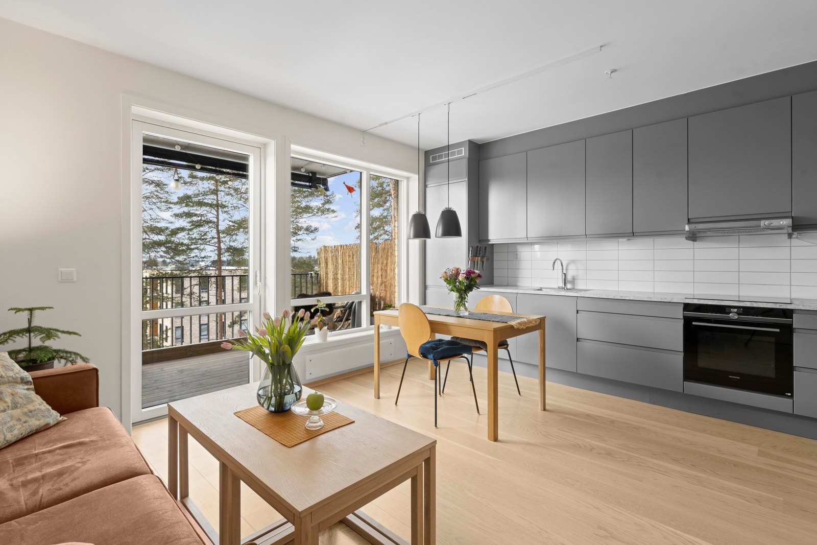 Åpen og romslig stue-/kjøkkenløsning med god plass til både spisebord og sofagruppe. Galleribilde