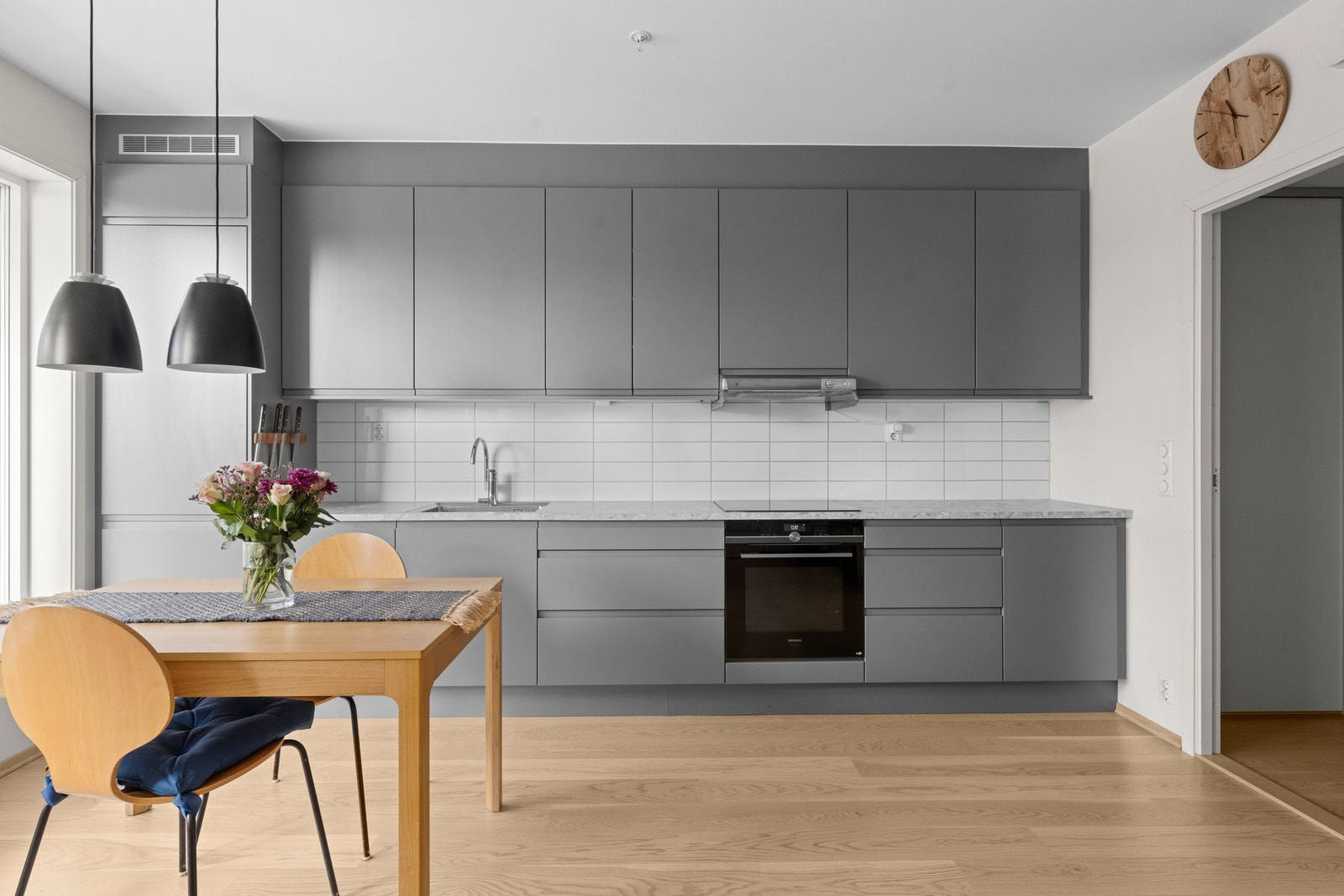 Kjøkkenet har moderne innredning med glatte fronter og laminert benkeplate, samt integrerte hvitevarer som kjøl/fryseskap, oppvaskmaskin, komfyr og induksjonstopp. Galleribilde