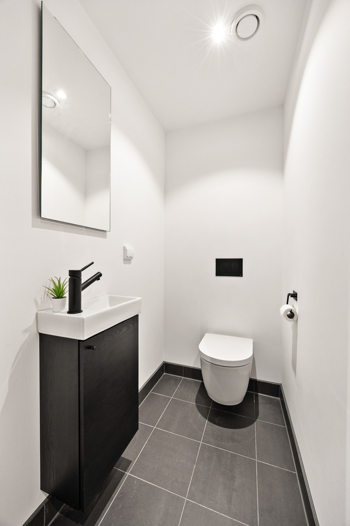 Et ekstra toalett i boligen er praktisk for gjester og familien. Rommet har servant med benkeskap og speil over servanten, samt et vegghengt toalett. Galleribilde