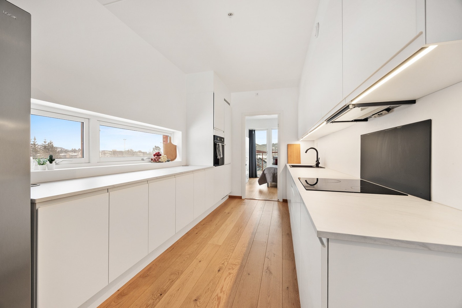 Leiligheten har et lekkert HTH-kjøkken med integrerte hvitevarer som kjøleskap, komfyr og oppvaskmaskin. Kjøkkeninnredning er hvit med glatte fronter. Det er også montert plate på vegg over platetopp Galleribilde