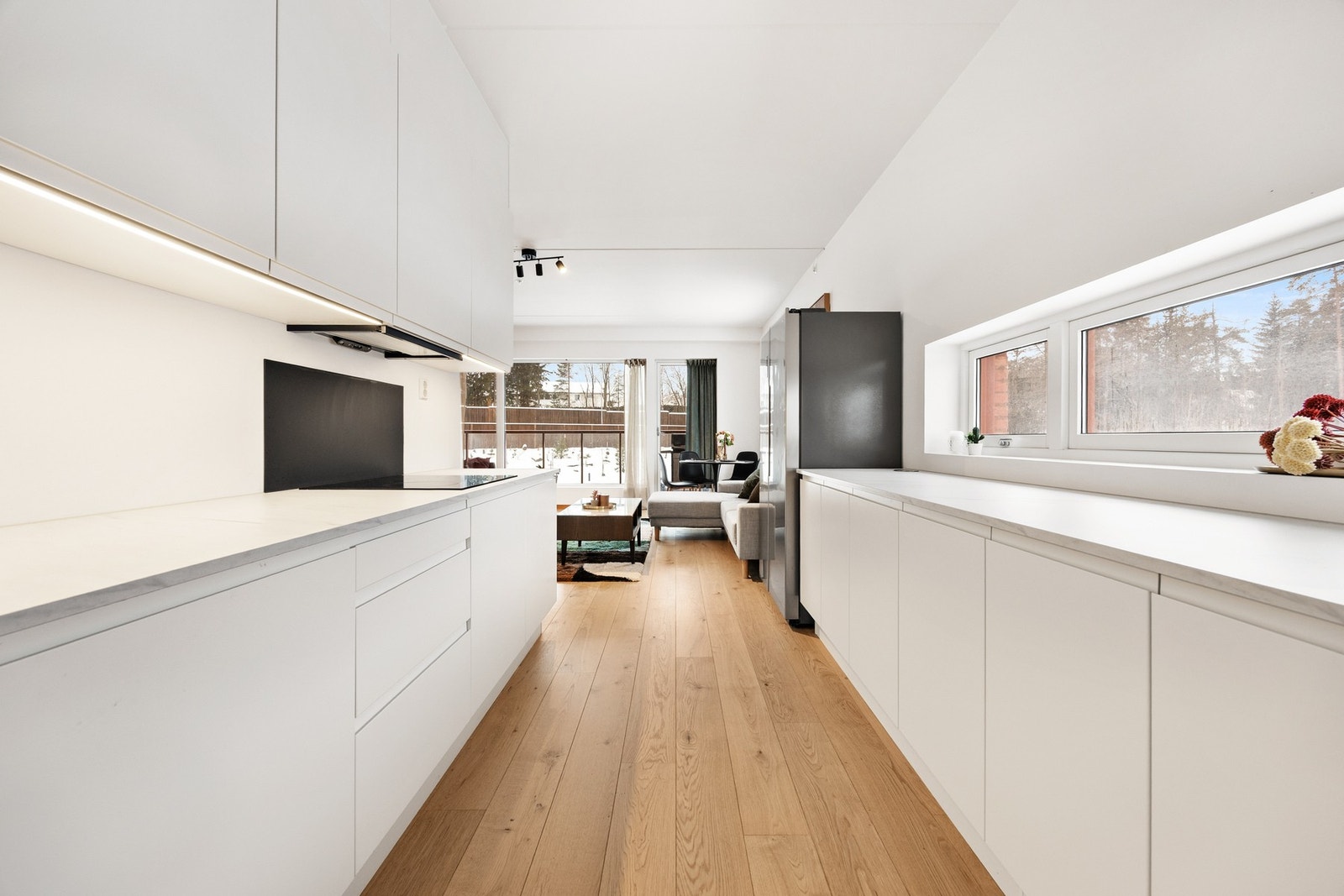 Leiligheten har et lekkert HTH-kjøkken med integrerte hvitevarer som kjøleskap, komfyr og oppvaskmaskin. Kjøkkeninnredning er hvit med glatte fronter, det er monter plate på vegg over platetopp Galleribilde