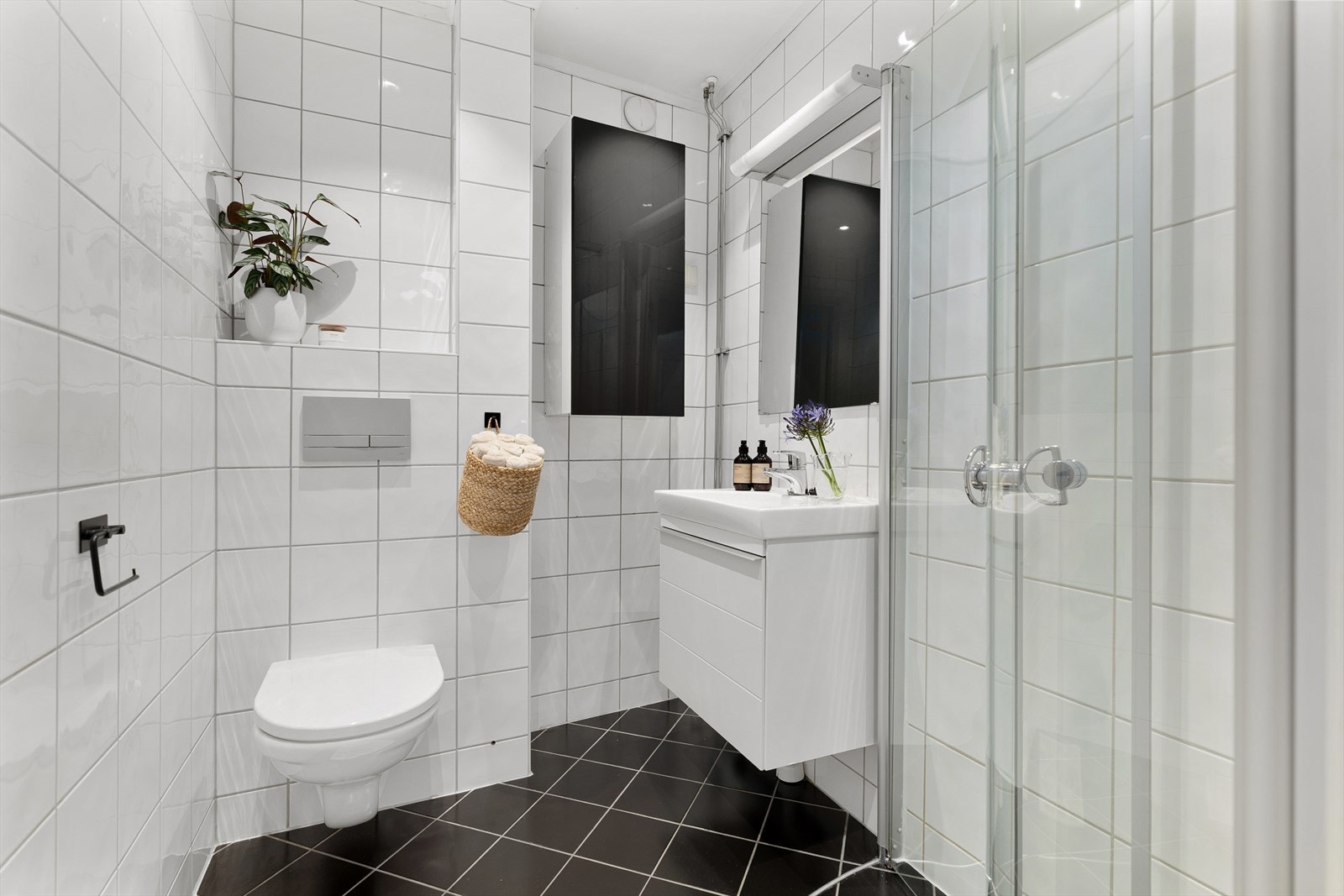 De svingbare dusjdørene gir ekstra gulvplass. Den integrerte hyllen over WCen er en fin oppbevaringsplass for planter og fine baderomsdetaljer. Det er opplegg til vaskemaskin ved siden av servantskapet. Galleribilde