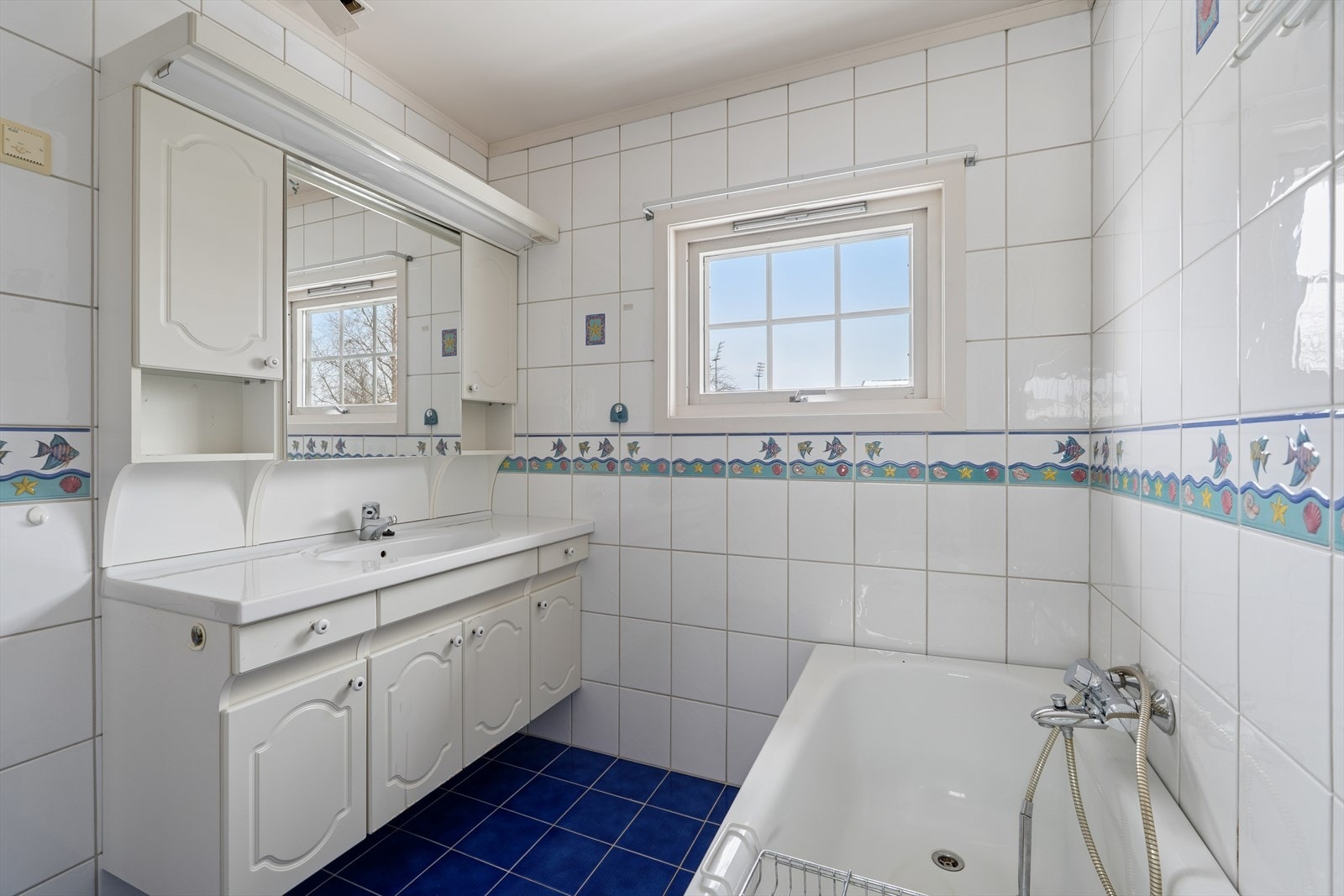 Flislagt bad med servant, god skapplass og badekar Galleribilde