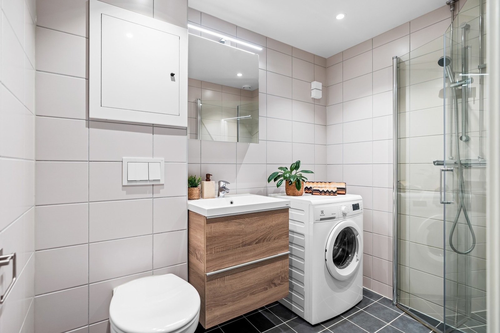 Badet er fra 2021 og har flislagte overflater med gulvvarme på gulv. Galleribilde