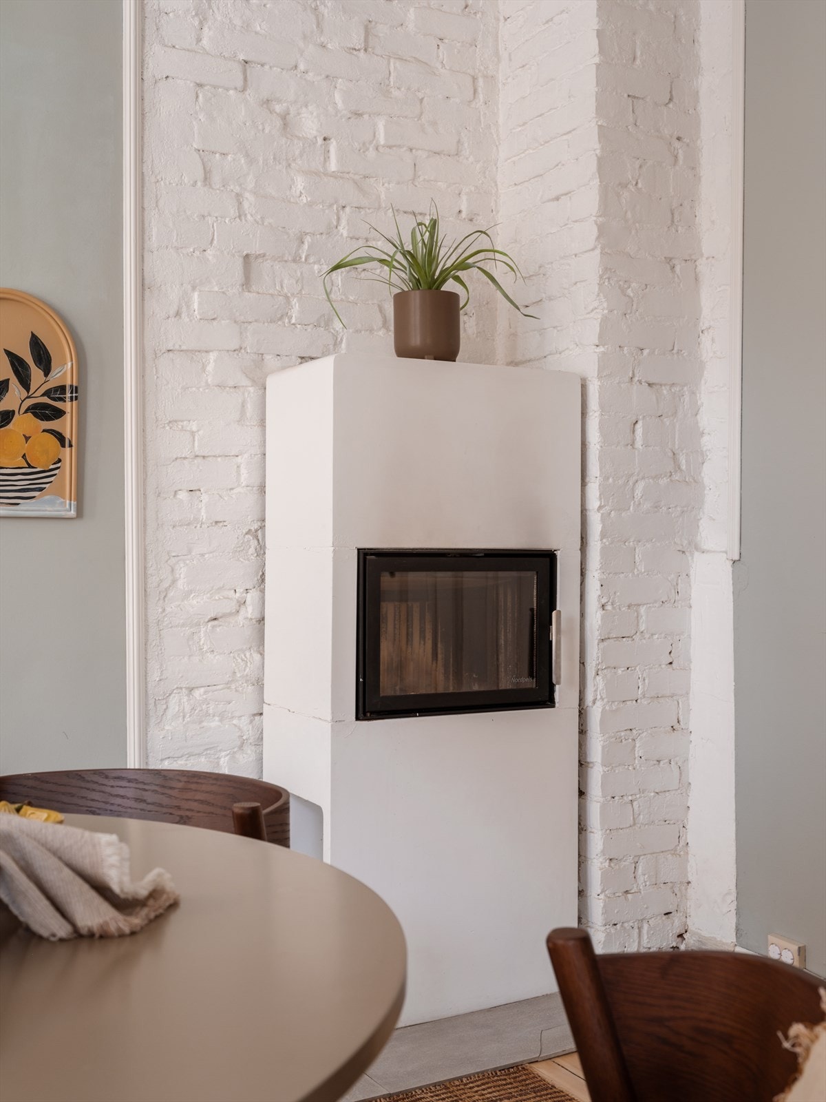 Peisovnen er plassert mot en eksponert teglsteinsvegg. Galleribilde