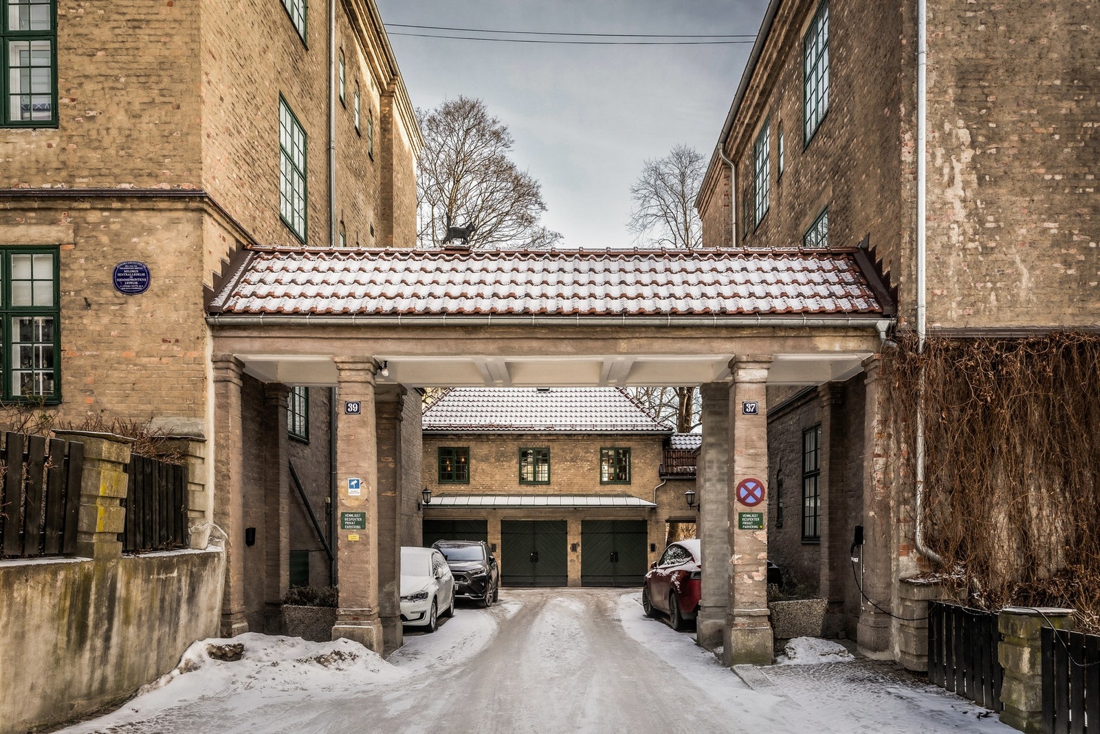 Det medfølger p-plass med opplegg til lader. Denne ligger helt til venstre i bildet, før portalen. Galleribilde