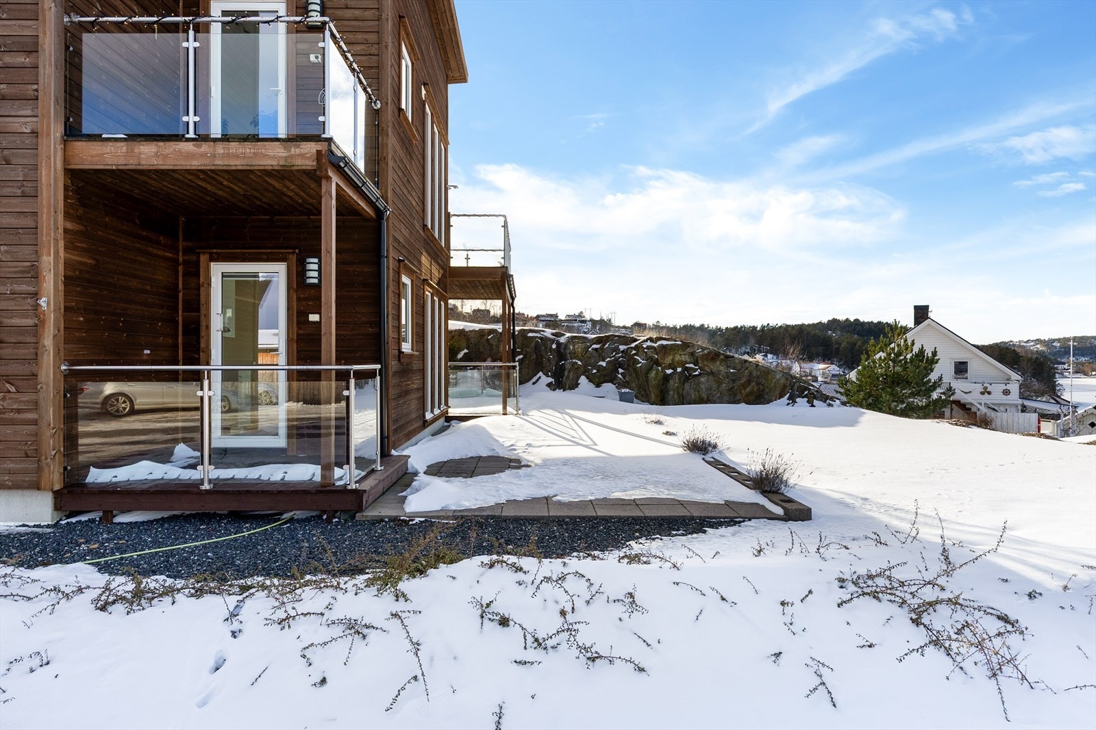 Overbygget terrasse med glassrekkverk og flott utsikt mot Kranfjorden og omkringliggende natur, en fin plass å nyte rolige dager. Galleribilde