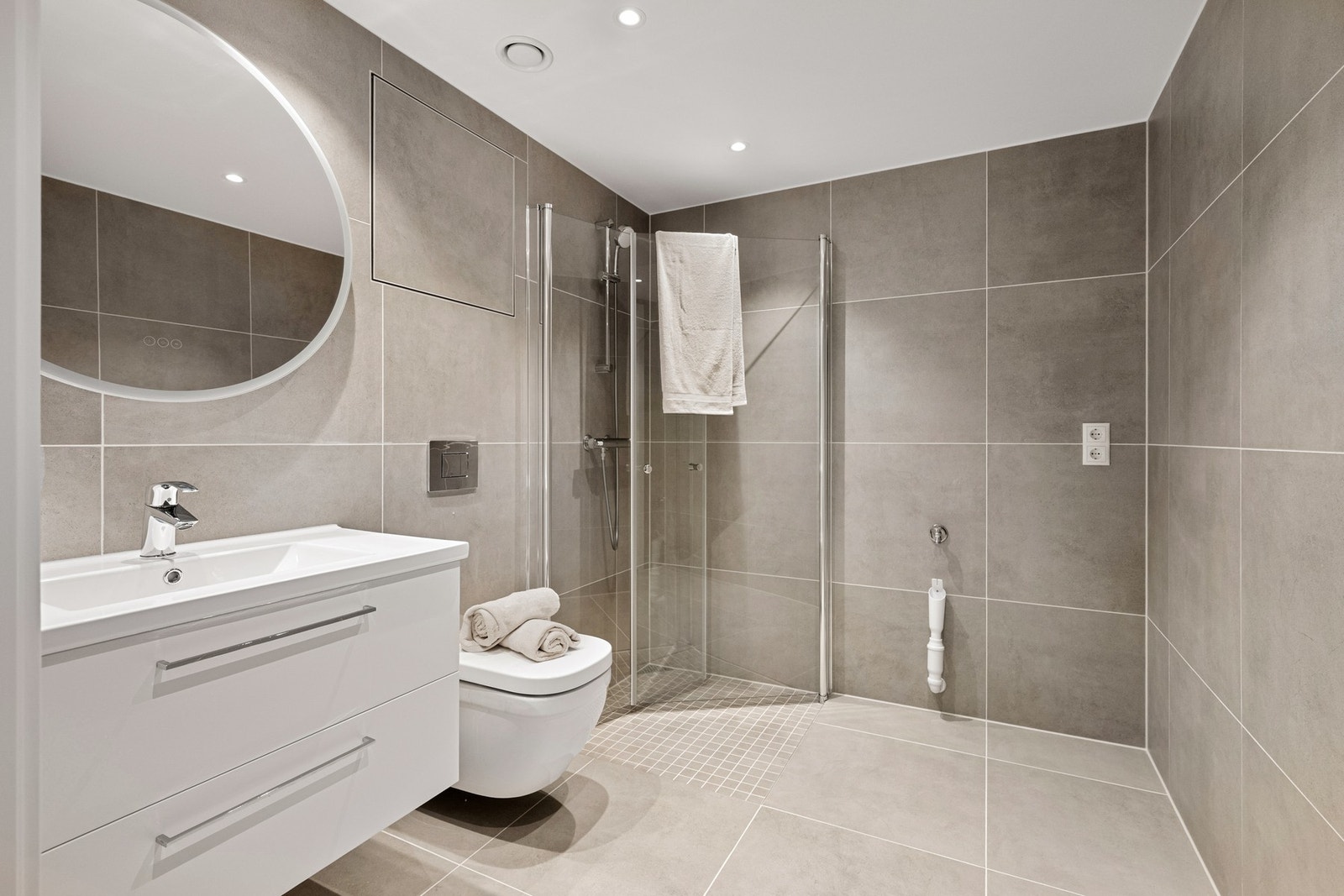 Badet fremstår som delikat og moderne, med fliser på både gulv og vegger som gir et helhetlig og stilrent uttrykk. Galleribilde