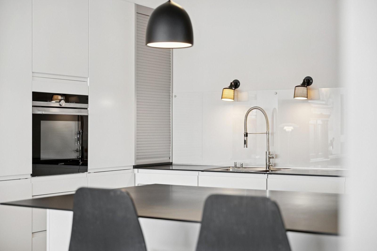 Slette hvite fronter samt takhøye over- og høyskap som gir rikelig med oppbevaringsplass. Galleribilde